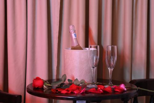 a table with a bottle of wine and two wine glasses at Hotel Partenon Beach in La Ceiba