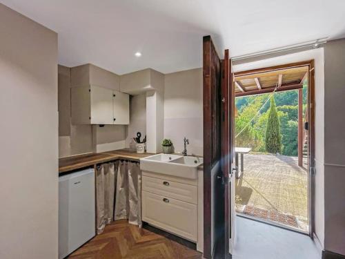 une cuisine avec un évier et une grande fenêtre dans l'établissement Dépendance du château avec jacuzzi privé, à Yzeron