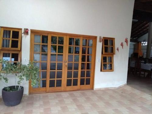 uma porta de madeira de um edifício com um vaso de plantas em Chacara muito bonita região de Limeira - Sp em Limeira
