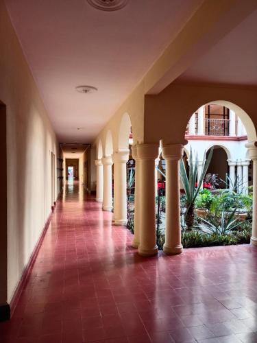 an empty hallway of a building with columns and plants at Hotel Los Monteros in Ciudad Victoria