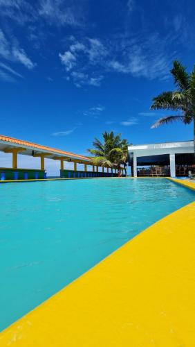 a large swimming pool with blue and yellow at Hotel Partenon Beach in La Ceiba