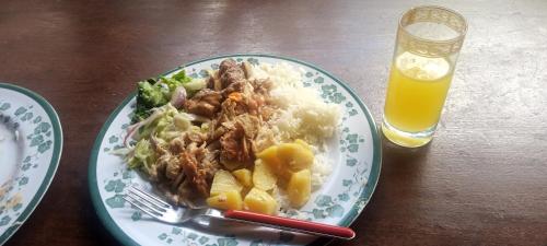 un plato de comida con arroz y un tenedor y un vaso de cerveza en Daliko Farm, 