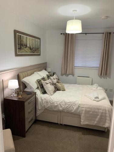 ein Schlafzimmer mit einem Bett, einer Kommode und einem Fenster in der Unterkunft SUNNY RHYL BUNGALOW in Rhyl