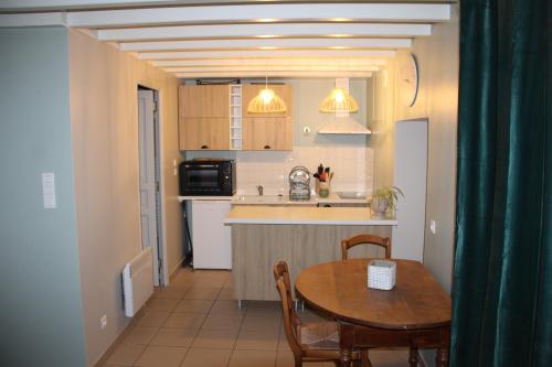 une cuisine et une salle à manger avec une table et des chaises dans l'établissement La p'tite maison, à Lussas-et-Nontronneau