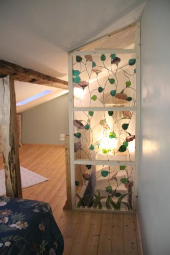 a room with a glass door with a vine wall at La p'tite maison in Lussas-et-Nontronneau