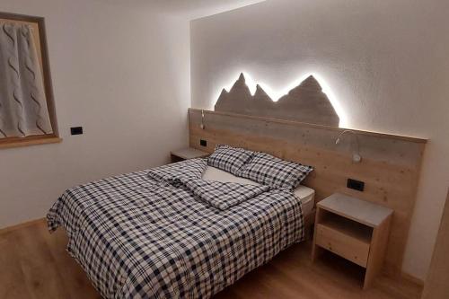 a bedroom with a bed with a checkered blanket at appartamento vacanze cima nana in Dimaro
