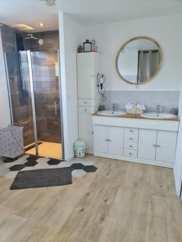 a bathroom with a shower and two sinks and a mirror at Charmante maison Les Cèdres Bleus in Loon-Plage