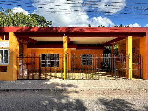 an orange building with a gate in front of it at Departamento 48 Street in Valladolid