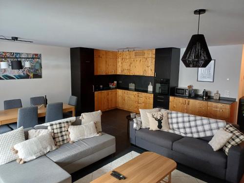 ein Wohnzimmer mit 2 Sofas und einer Küche in der Unterkunft Spacieux appart 3,5 pièces incl Jaccuzzi Privé in Leukerbad