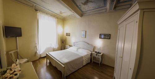 a bedroom with a white bed and a window at Residenza d'Epoca Relais I Miracoli in Pisa