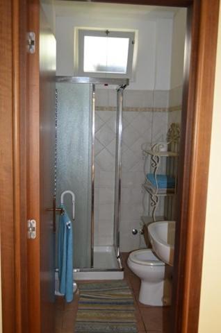 a bathroom with a shower and a toilet and a window at Rinaldi's Apartment in Sirolo