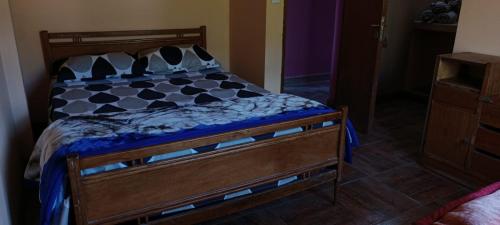 1 dormitorio con 1 cama con marco de madera en Casa Mamani en Tilcara