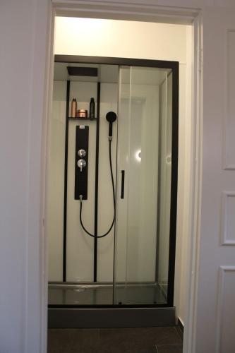 a room with a shower with a phone in a glass door at Beach House Ängelholm in Ängelholm