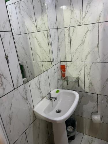 a white sink in a bathroom with marble walls at Apart Belén in Puerto Iguazú