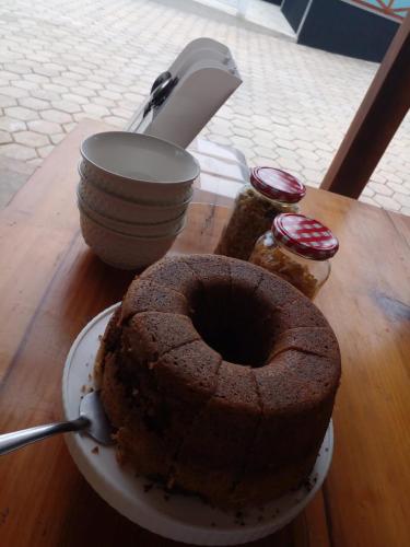 a cake on a plate on a table with a spoon at Pousada Chalés Vale Sereno Classic's in Camanducaia