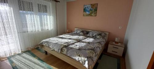 a small bedroom with a bed and a window at Apartment ROKO with sauna & view in Brod Moravice