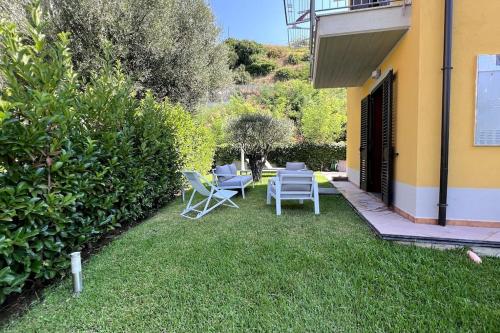 a yard with chairs and a table and a building at Villetta a pochi passi dal mare e dal centro Marina di Ascea in Marina di Ascea