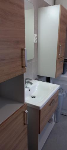 a bathroom with a white sink and a mirror at Apartment ROKO with sauna & view in Brod Moravice