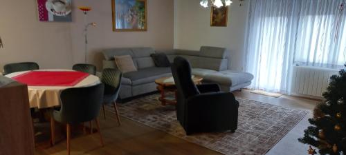 a living room with a couch and a table with chairs at Apartment ROKO with sauna & view in Brod Moravice