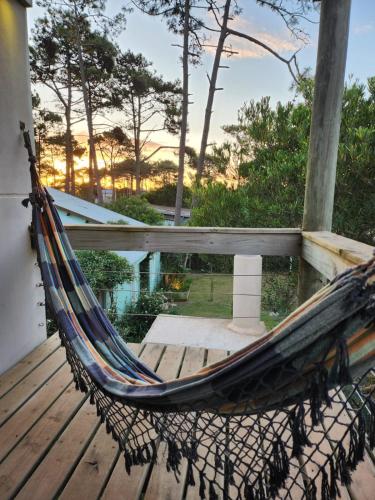 a hammock on a deck with a view of a pool at MarEz in Punta Del Diablo