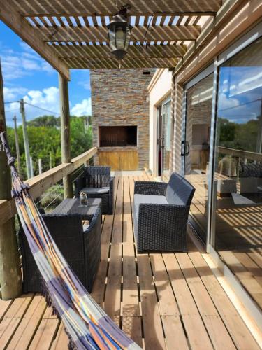 a hammock on a deck with a fireplace at MarEz in Punta Del Diablo