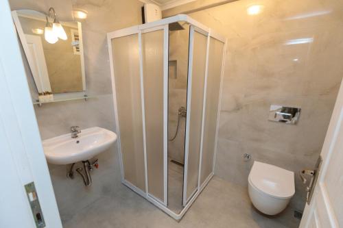 a bathroom with a shower and a toilet and a sink at Lale Apartments Fethiye in Fethiye