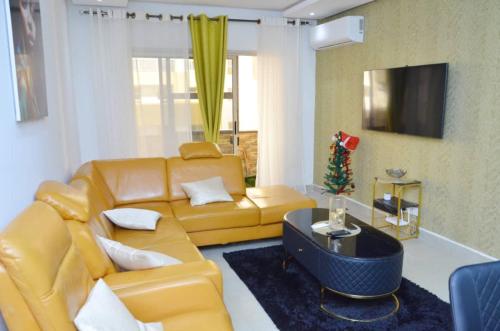 a living room with a yellow couch and a christmas tree at F3 Dakar Plateau Appartement Cité Emmergence in Dakar