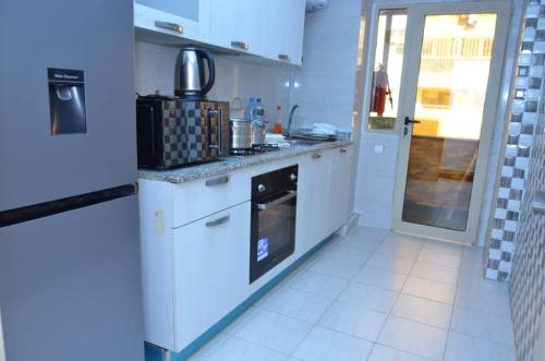 a kitchen with white cabinets and a stove top oven at F3 Dakar Plateau Appartement Cité Emmergence in Dakar