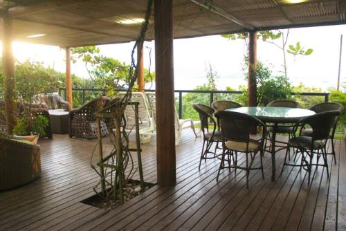 a patio with a table and chairs on a deck at Jurerê - Direto na Praia in Florianópolis