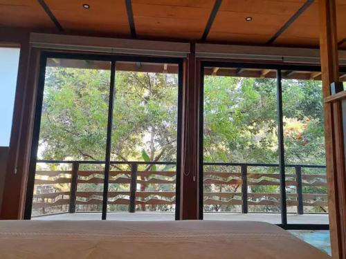 a bedroom with a bed and large glass windows at Frondavista San Pancho in San Francisco