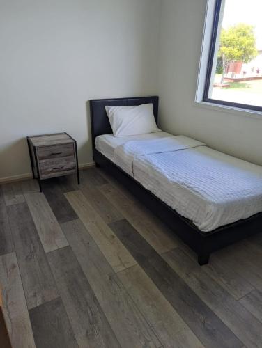 a bedroom with a bed and a night stand and a window at Huge Holiday Home 4Beds 2Baths in Gladstone near Shopping Center in Gladstone