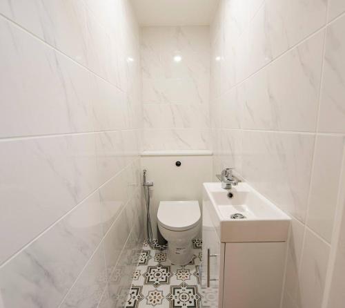 bagno bianco con servizi igienici e lavandino di Large Cosy Property 15min from Central London a Londra