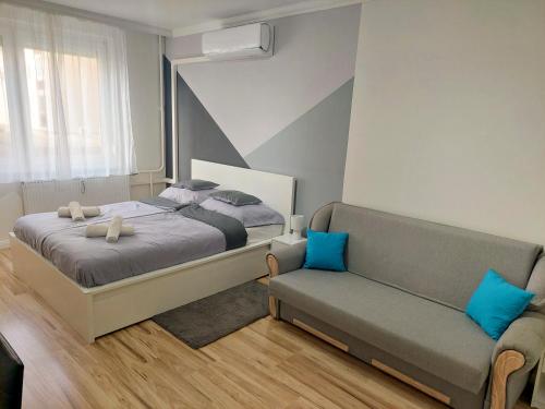 ein Schlafzimmer mit einem Bett und einem Sofa in der Unterkunft AwesHome City Apartment in Debrecen