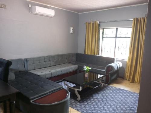 a living room with a couch and a table at Ramachi apartments in Livingstone