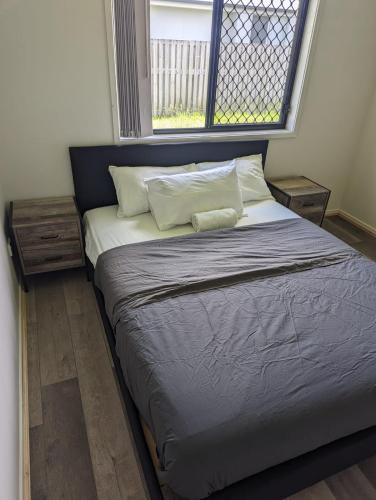 a large bed in a room with a window at Christa's 4Bedroom Entire Private House Gladstone City in Gladstone