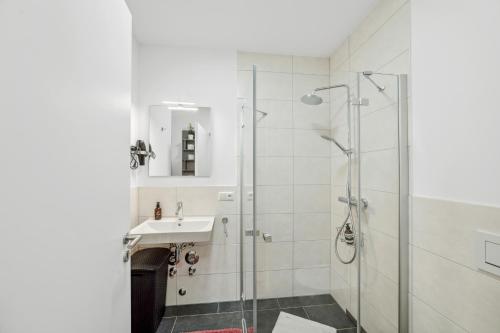 uma casa de banho com um chuveiro e um lavatório. em Sali Homes R3 Gemütlichkeit am Rother Mainufer em Bayreuth