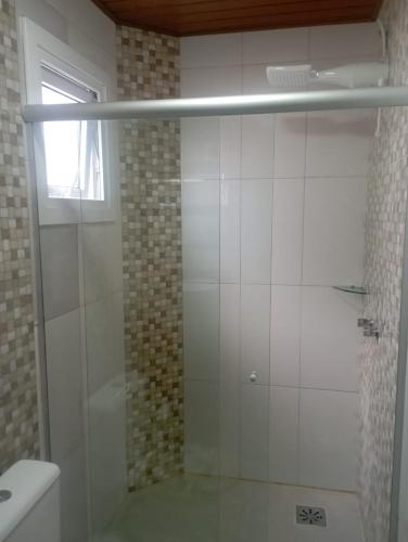 eine Dusche mit Glastür im Badezimmer in der Unterkunft Aconchego Apartamentos da Serra in Canela