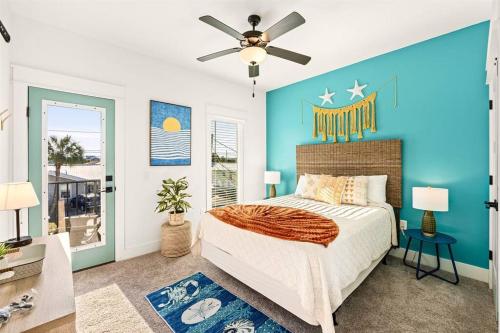 a bedroom with blue walls and a bed with a ceiling fan at Sand Castle in Panama City Beach