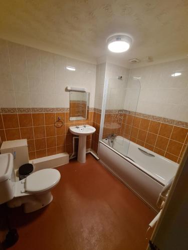 łazienka z toaletą, umywalką i wanną w obiekcie Devon Towers Hotel w Bournemouth