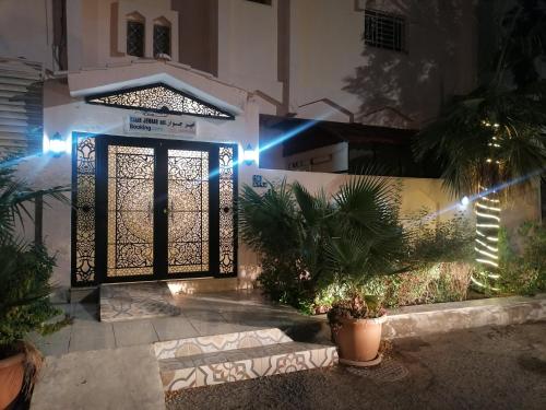 Khair Jewaar Apartments Al Madinah في المدينة المنورة: باب المنزل في الليل مع وجود الانارة