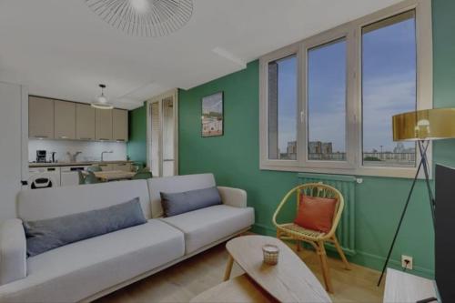 - un salon avec un canapé blanc et un mur vert dans l'établissement Appartement neuf pour 6, parking et box, au calme, à Villeurbanne