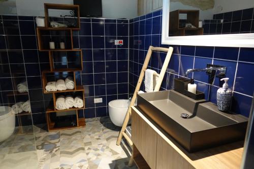 ターラントにあるle stanze di Eurialoの青いタイルのバスルーム(洗面台、トイレ付)