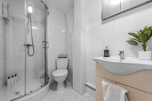 Baño blanco con aseo y lavamanos en Deluxe flat on Kentish Town en Londres