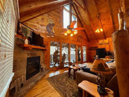 a living room with a fireplace in a log cabin at Smoky Paws - Exceptional Cabin, Stunning Mountain Views, Hot Tub, Tranquil, Gigabit Internet, Free L2 EV in Pigeon Forge