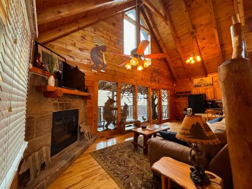 a living room with a fireplace in a log cabin at Smoky Paws - 5-star Cabin, Stunning Mountain Views, New Hot Tub, Tranquil, Gigabit Internet, Free L2 EV in Pigeon Forge