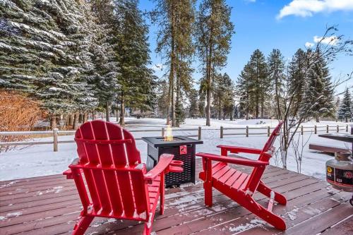 two red chairs sitting on a deck with a grill at Ponderosa in McCall