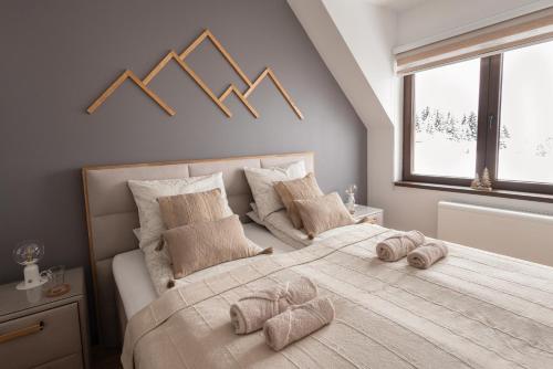um quarto com uma cama grande e toalhas em Glečer Kop, apartment A14 em Kopaonik