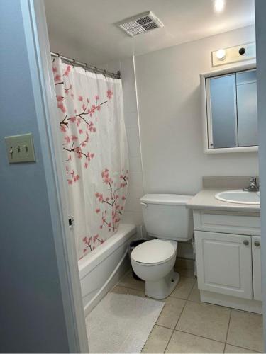 a bathroom with a toilet and a sink and a shower curtain at Osaru Abel Omoruyi in Mississauga