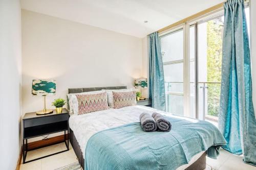 ein Schlafzimmer mit einem Bett und einem großen Fenster in der Unterkunft 2 BR Flat Edgware Road in London