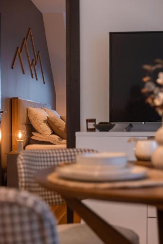 a dining room with a table and a television at Glečer Kop, Apartment A14, FREE Parking Garage in Kopaonik